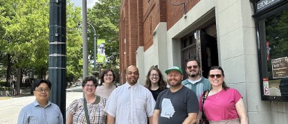 Group of people standing in front of a building under a sign that says Ebenezer Baptist Church.