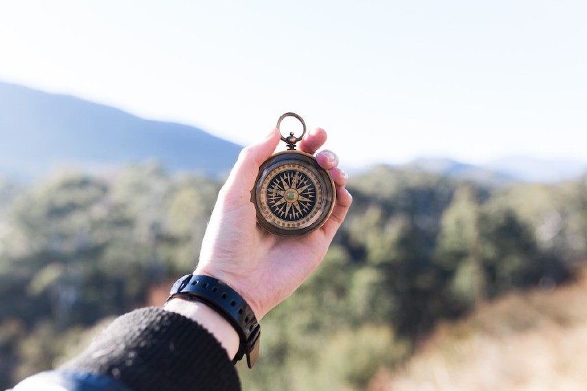 hand extended holding a compass outdoors
